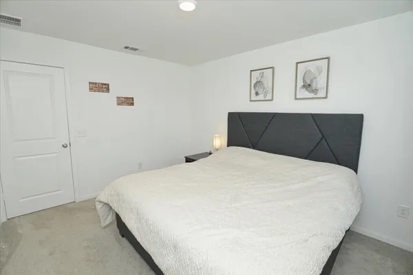 a bedroom with a bed and painting on the wall