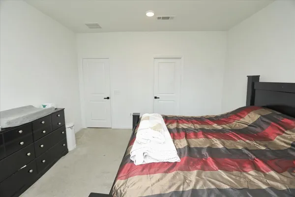 a bedroom with a bed and a dresser