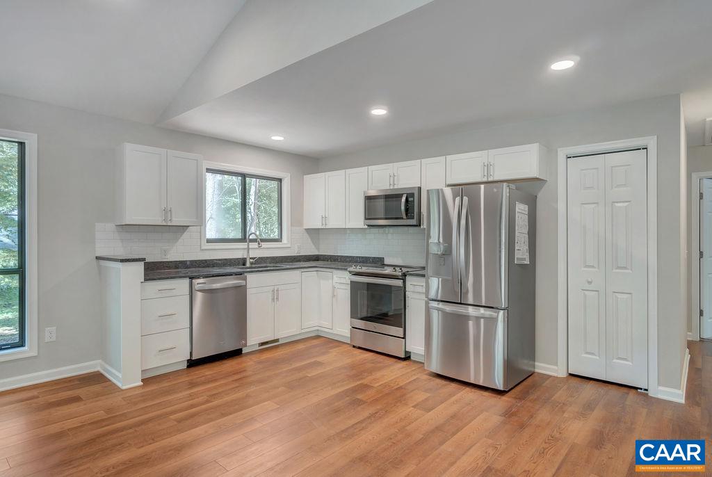 26 Dogleg Road Palmyra, VA 22963 - Photo 24 of 48 a kitchen with granite countertop a refrigerator stove and wooden floor