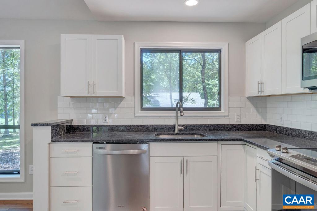 26 Dogleg Road Palmyra, VA 22963 - Photo 25 of 48 a kitchen with granite countertop white cabinets white appliances and a window
