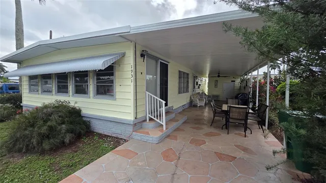 a view of a house with backyard sitting area and garden