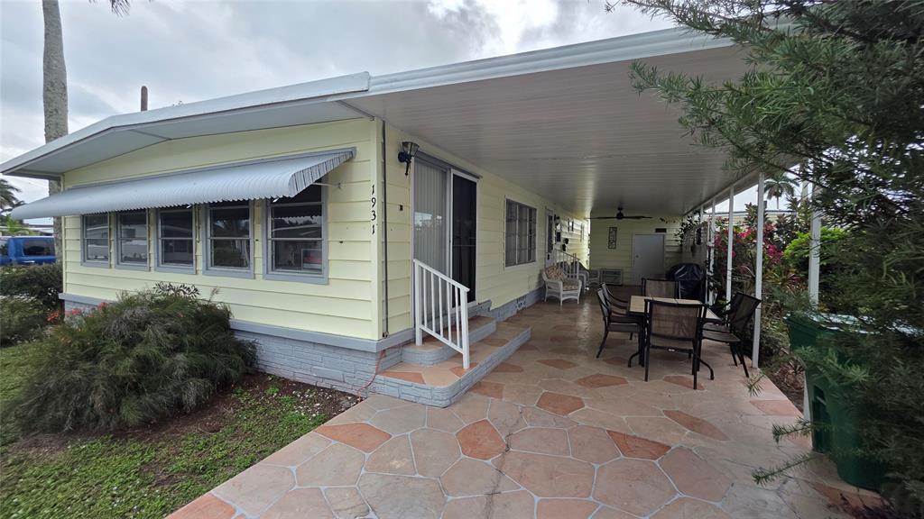 a view of a house with backyard sitting area and garden