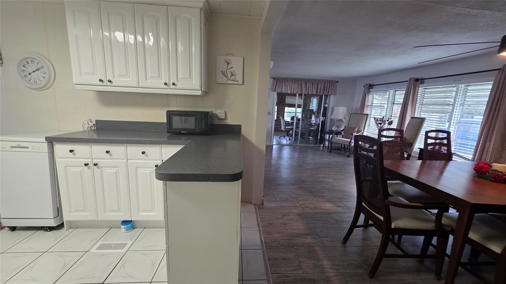 1931 Southwest 85th Avenue Davie, FL 33324 - Photo 11 of 35 a kitchen with stainless steel appliances granite countertop a dining table chairs and a refrigerator