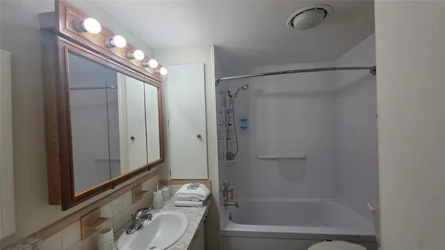 a bedroom with a bed and a flat tv screen on dresser