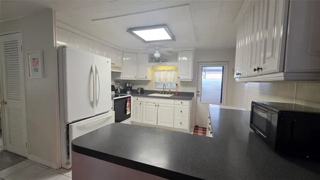 a kitchen with a refrigerator a stove top oven and cabinets