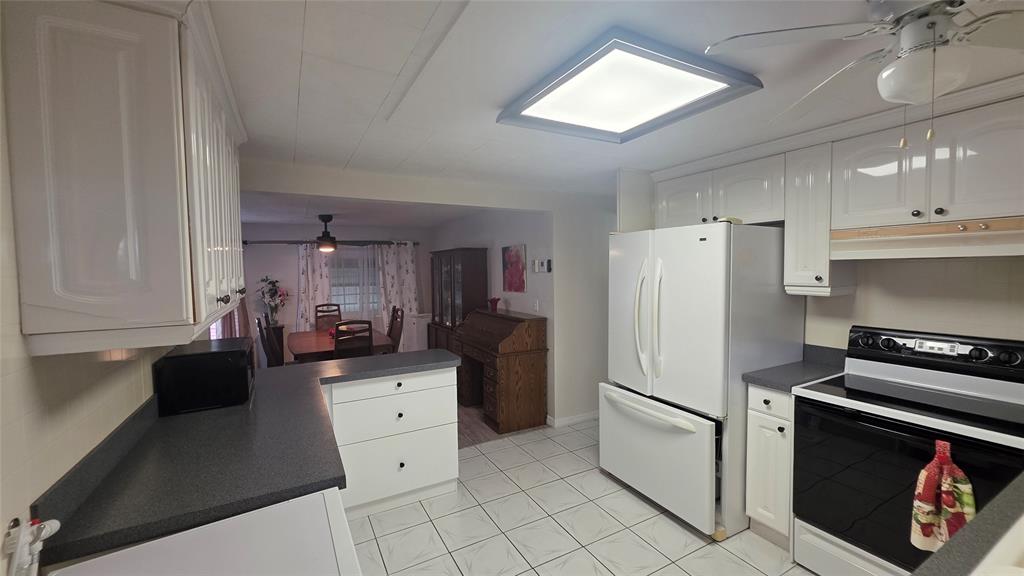 1931 Southwest 85th Avenue Davie, FL 33324 - Photo 9 of 35 a kitchen with a refrigerator a stove top oven and cabinets