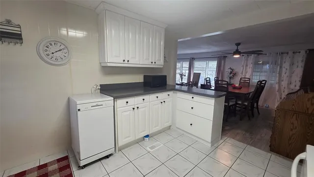 a kitchen with stainless steel appliances granite countertop a dining table chairs and a refrigerator