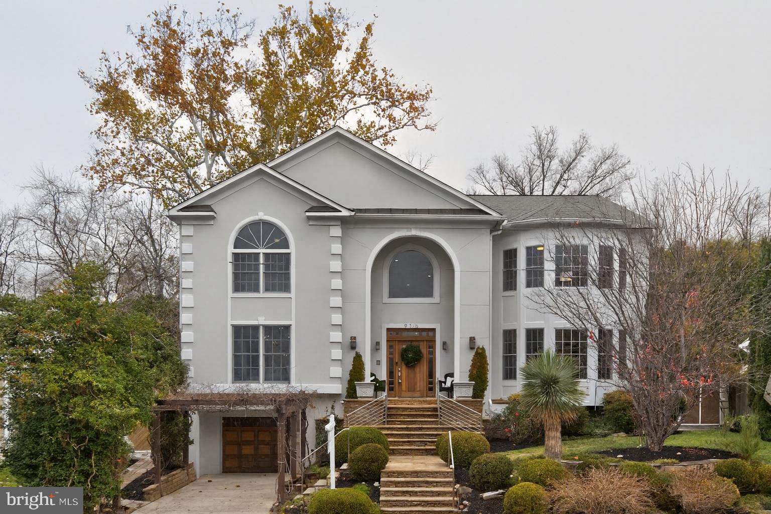 a view of a white house with large windows and a small yard