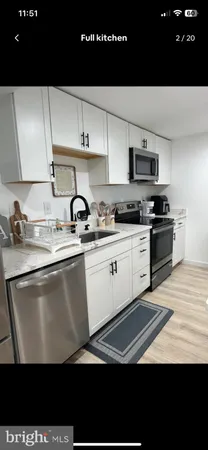 a kitchen with stainless steel appliances a sink a stove and cabinets