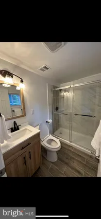 a bathroom with a sink mirror toilet and shower