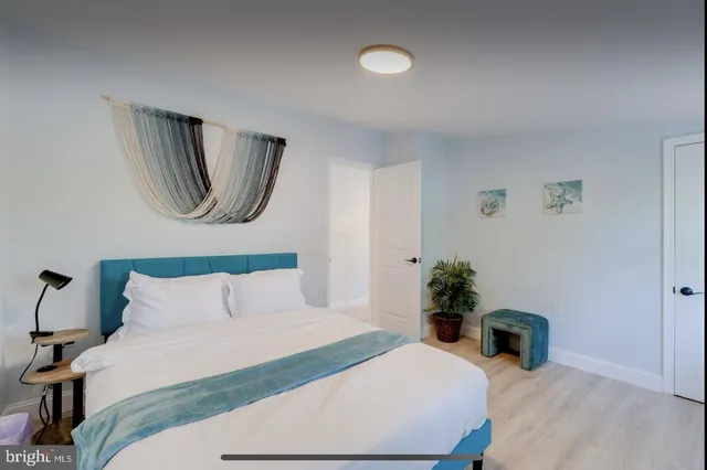 a bedroom with a bed a potted plant and a fireplace