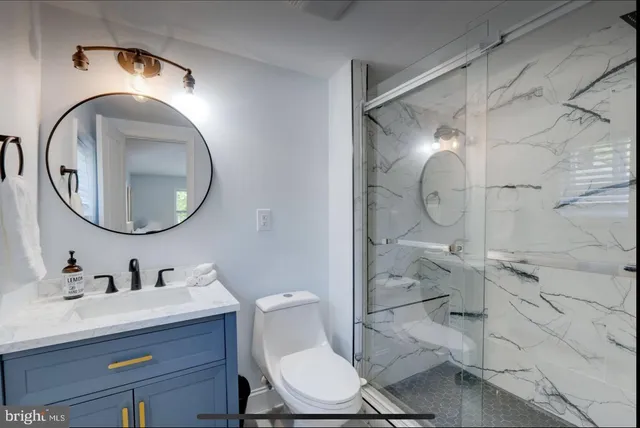 a bathroom with a toilet a sink and mirror