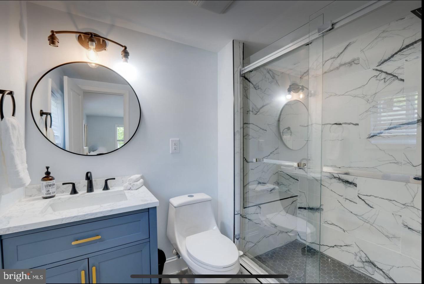 23794-23790 St Clair Road California, MD 20619 - Photo 6 of 20 a bathroom with a toilet a sink and mirror