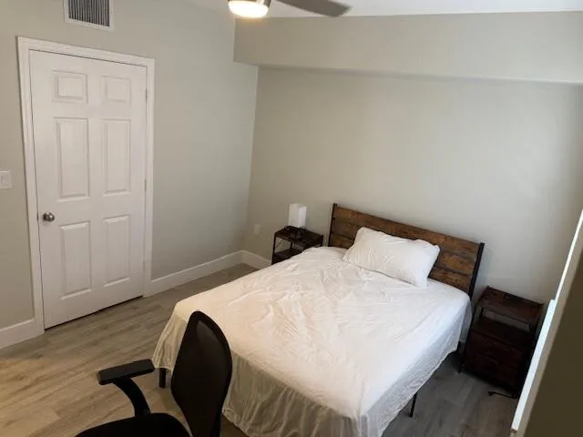 a bedroom with a bed and wooden floor