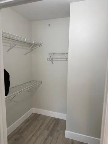 a view of a hallway with wooden shelves