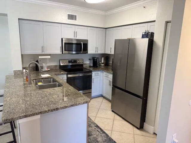 a kitchen with granite countertop a refrigerator and a sink