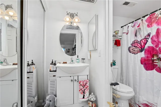 a bathroom with a sink mirror vanity and toilet