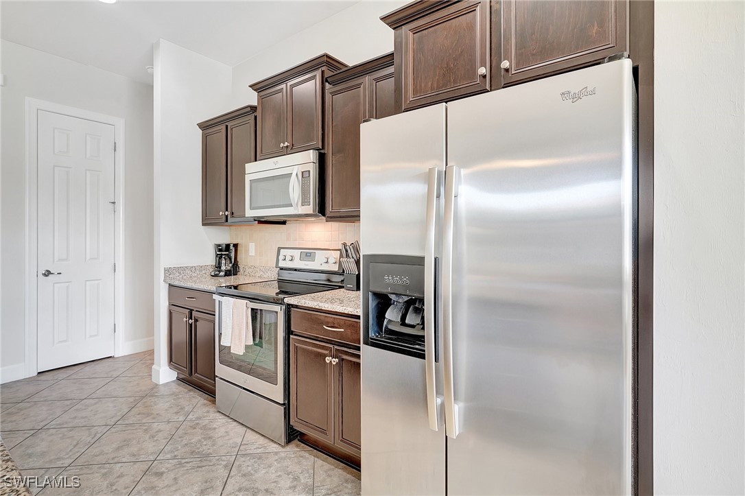 10879 Rutherford Road Fort Myers, FL 33913 - Photo 11 of 36 a kitchen with stainless steel appliances granite countertop a refrigerator and a stove