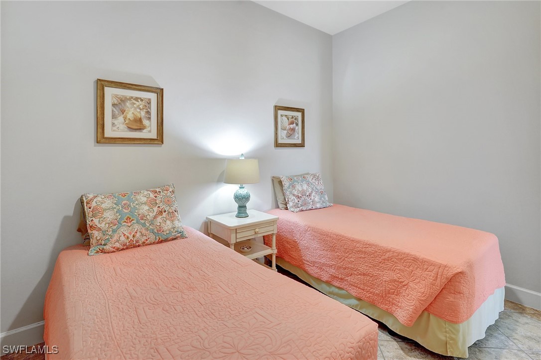 10879 Rutherford Road Fort Myers, FL 33913 - Photo 17 of 36 a bedroom with two beds and a lamp on dresser