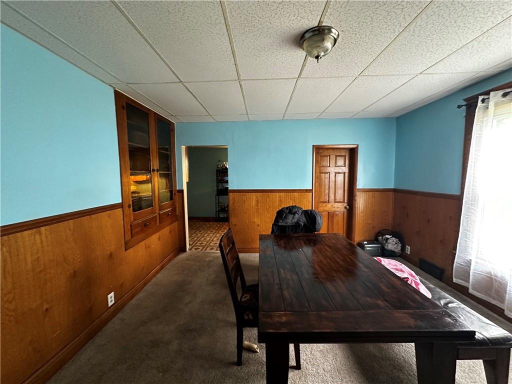 606 Chestnut Street New Castle, PA 16101 - Photo 4 of 12 a living room with a table chairs and a refrigerator