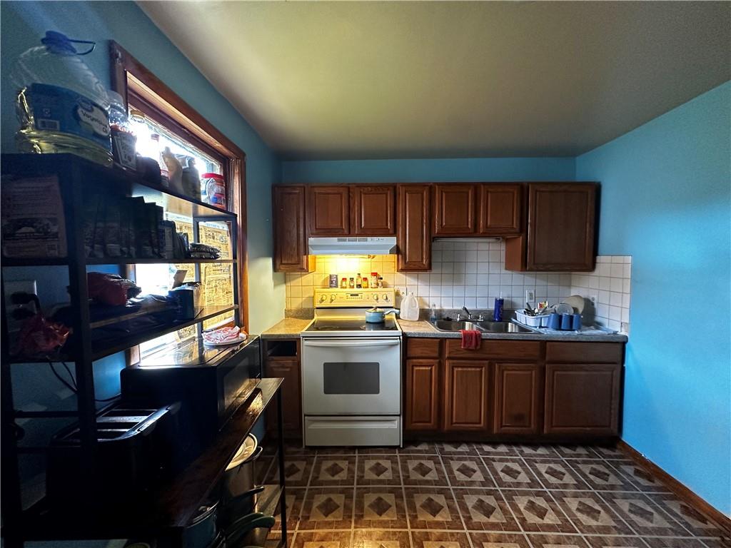 606 Chestnut Street New Castle, PA 16101 - Photo 5 of 12 a kitchen with stainless steel appliances granite countertop a stove a sink and a refrigerator