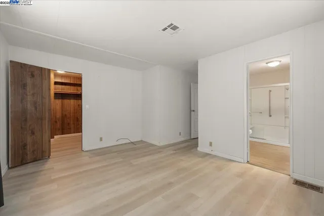 a view of an empty room with closet and a window