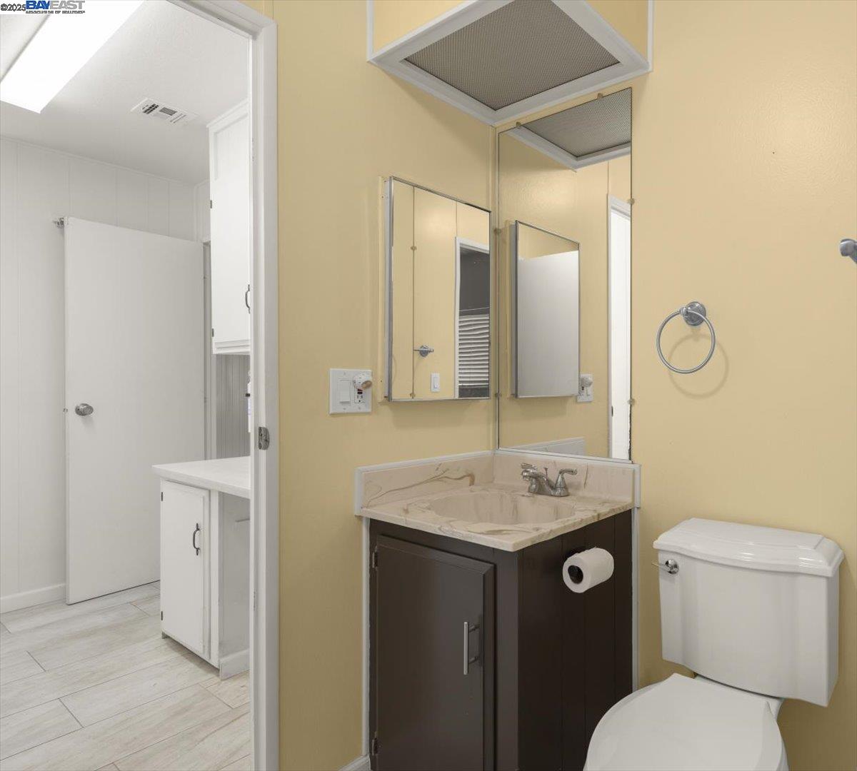 3263 Vineyard Avenue, Unit 44 Pleasanton, CA 94566 - Photo 28 of 31 a bathroom with a granite countertop sink toilet and mirror