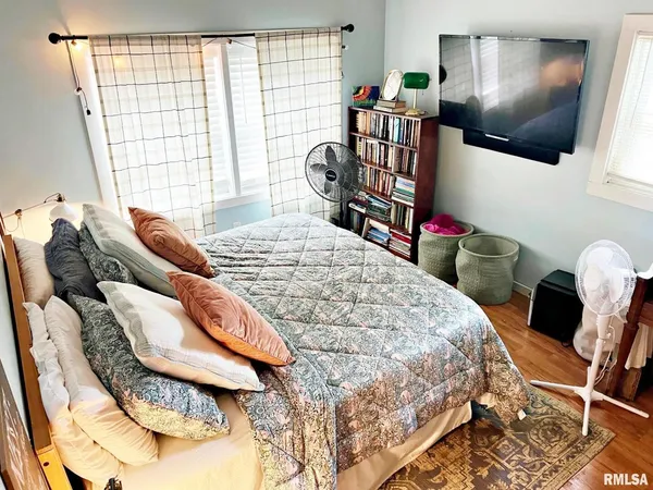 a bedroom with a bed a bookshelf and a window