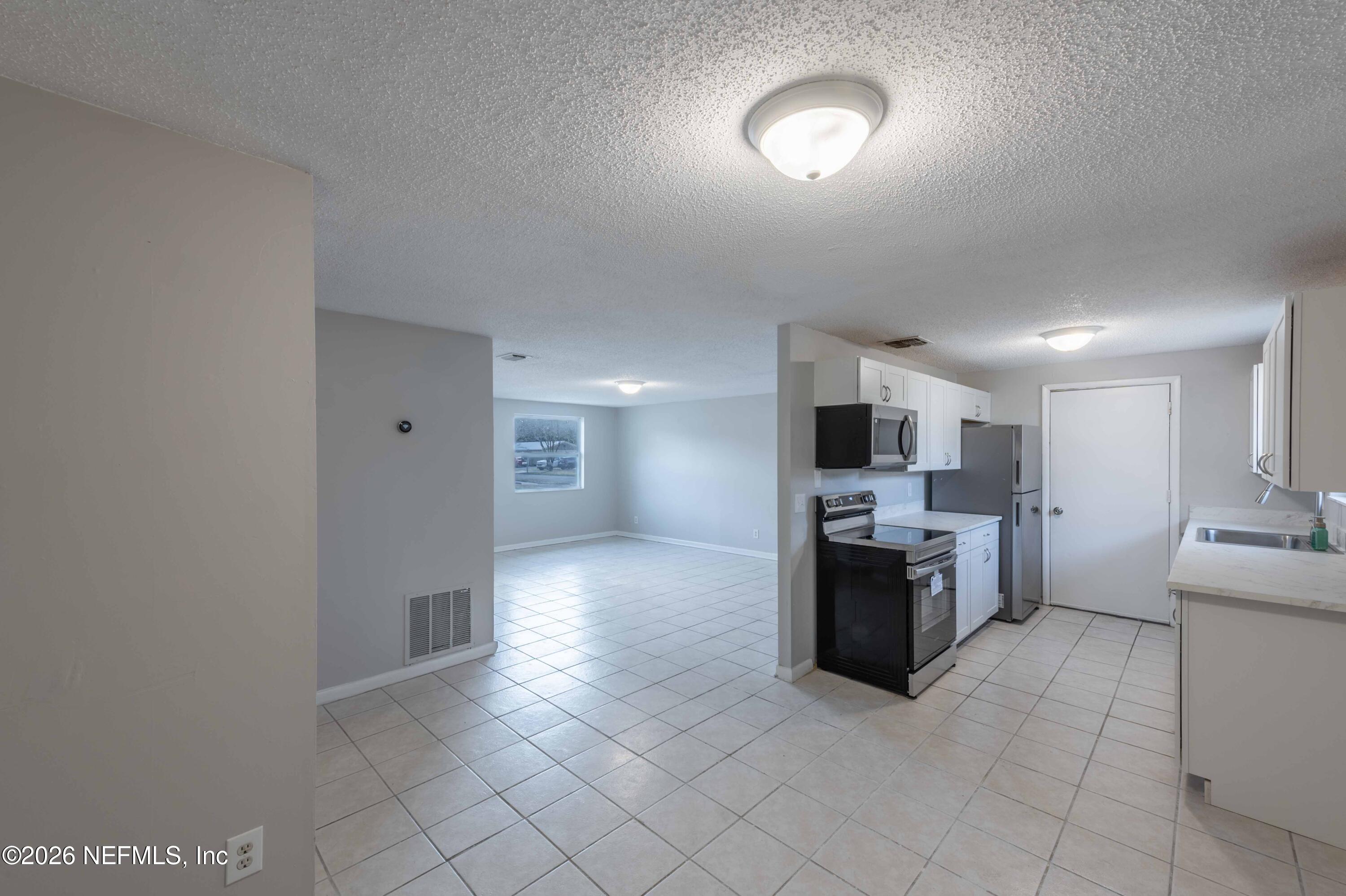 11605 Bayou Road Jacksonville, FL 32246 - Photo 21 of 39 a large kitchen with cabinets and stainless steel appliances