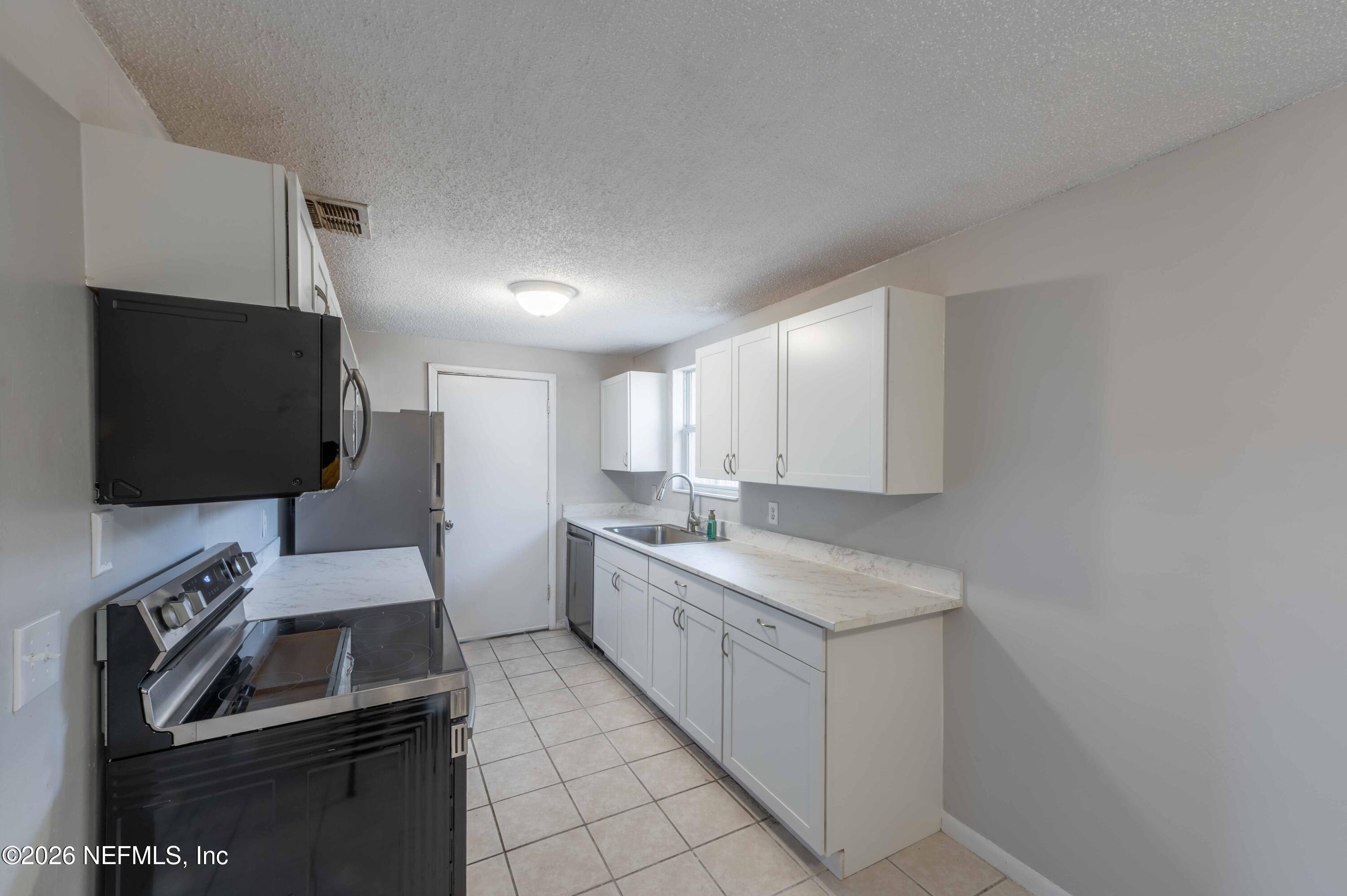 11605 Bayou Road Jacksonville, FL 32246 - Photo 22 of 39 a kitchen that has a sink and a stove