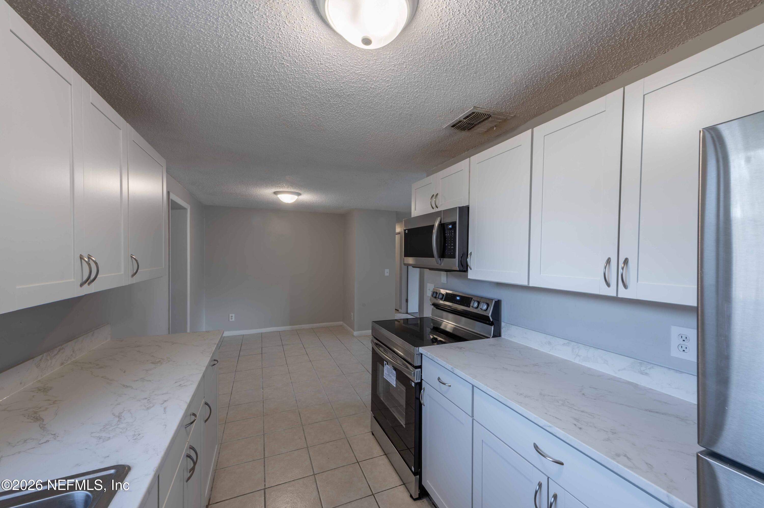 11605 Bayou Road Jacksonville, FL 32246 - Photo 24 of 39 a kitchen with stainless steel appliances granite countertop a sink a stove and a refrigerator