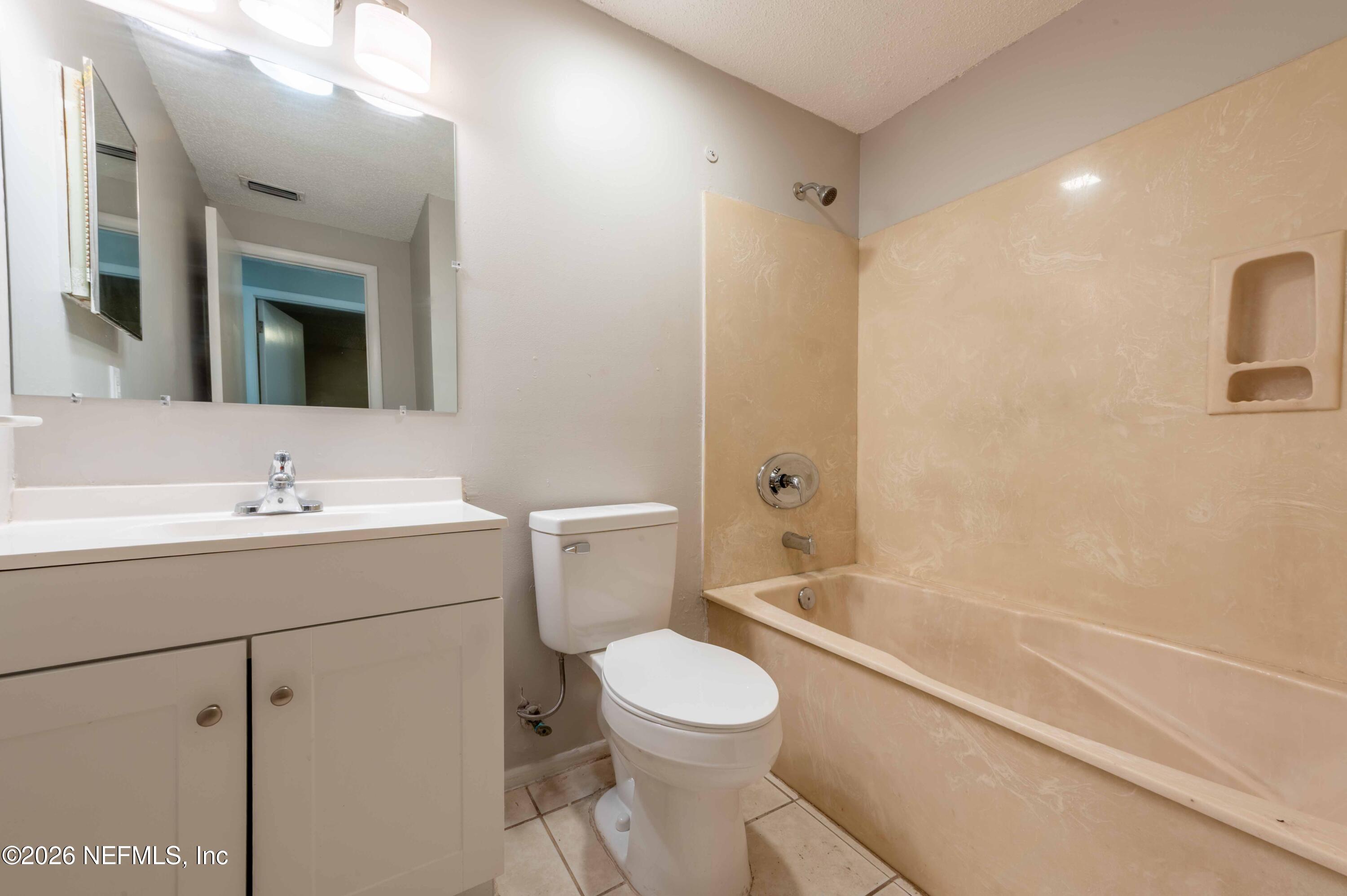 11605 Bayou Road Jacksonville, FL 32246 - Photo 32 of 39 a bathroom with a toilet sink shower and mirror