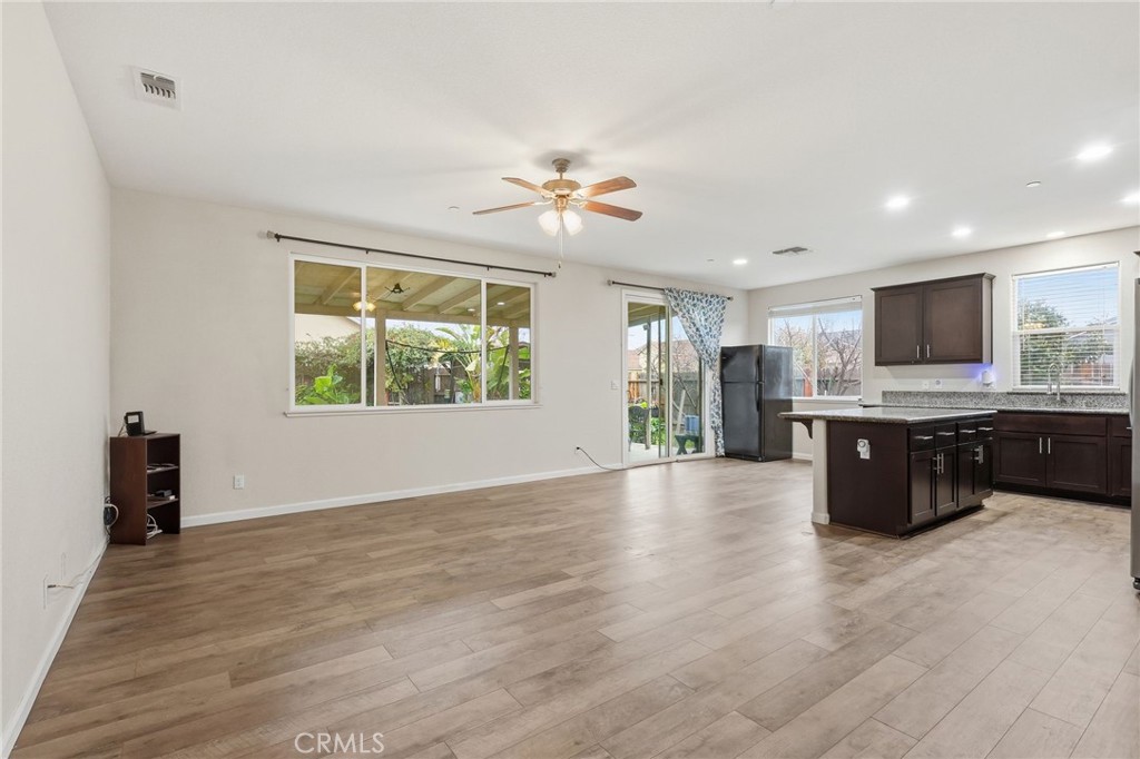 511 Glendon Court Merced, CA 95348 - Photo 11 of 37 a living room with furniture and a flat screen tv with kitchen view