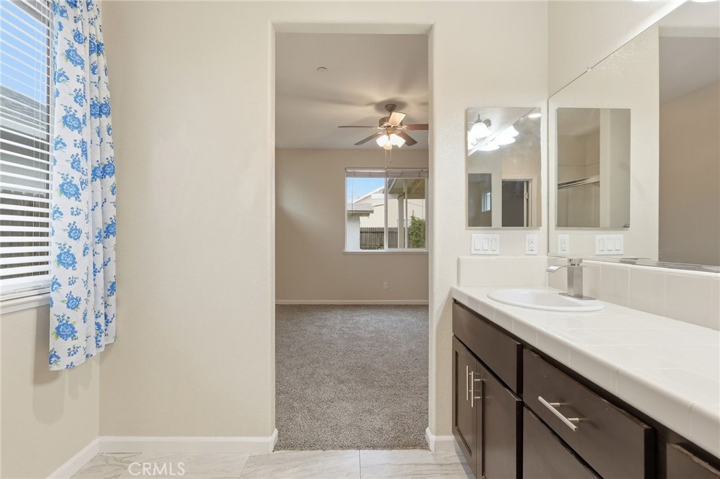 511 Glendon Court Merced, CA 95348 - Photo 24 of 37 a en suite bathroom with a granite countertop sink mirror and