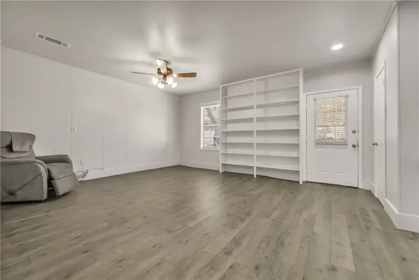 wooden floor in an empty room with a ceiling fan
