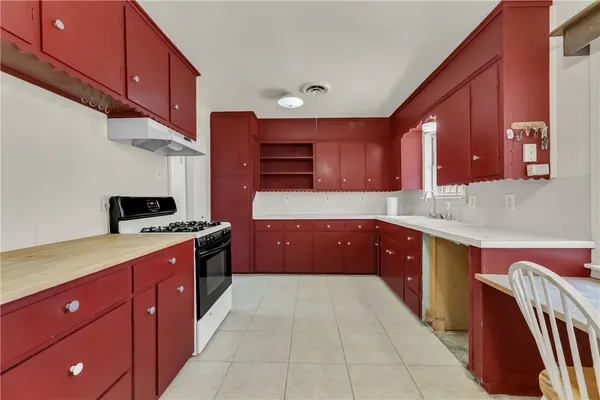 a kitchen with stainless steel appliances granite countertop a stove a sink dishwasher and a refrigerator with wooden cabinets