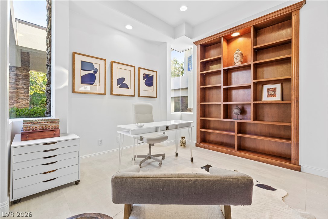 2000 Grouse Street Las Vegas, NV 89134 - Photo 8 of 89 A well-lit study with recessed lighting features built-in wooden shelving, offering a refined workspace.