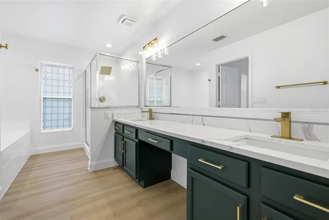 a spacious bathroom with a sink double vanity granite and a mirror