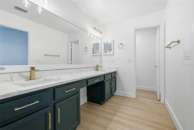 a spacious bathroom with a granite countertop sink and a mirror