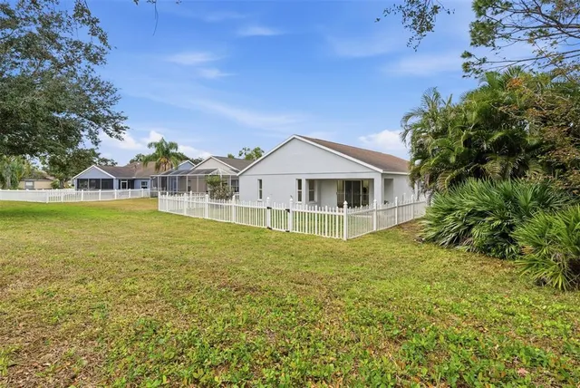 a view of a house with a big yard and large trees