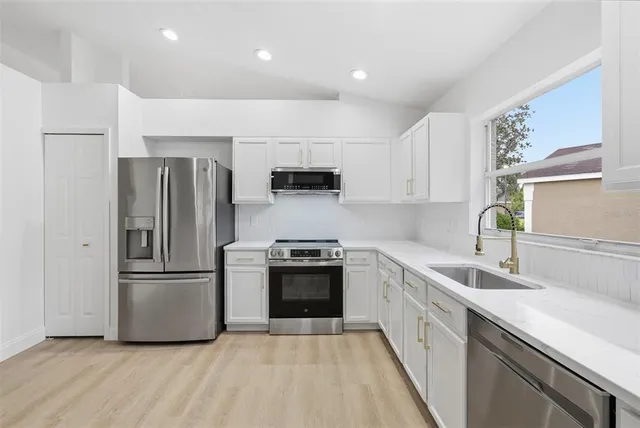 a kitchen with a refrigerator sink and wooden cabinets