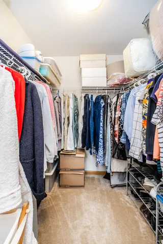 a view of walk in closet with clothes and shoes