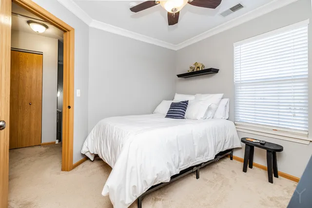 a bedroom with a bed and a ceiling fan