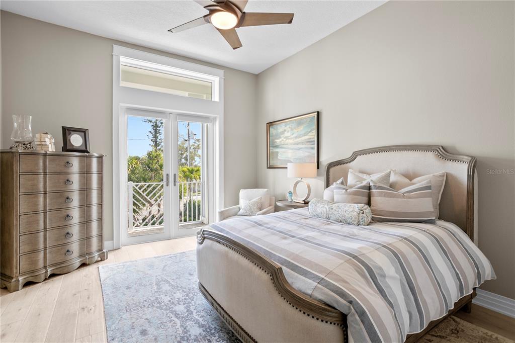 15612 Gulf Boulevard Redington Beach, FL 33708 - Photo 44 of 92 a bedroom with a balcony a bed and a chandelier