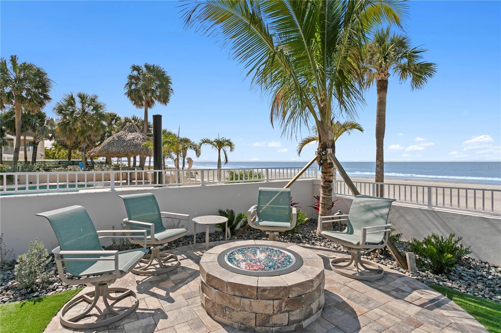 15612 Gulf Boulevard Redington Beach, FL 33708 - Photo 68 of 92 a view of a patio with table and chairs potted plants and palm tree