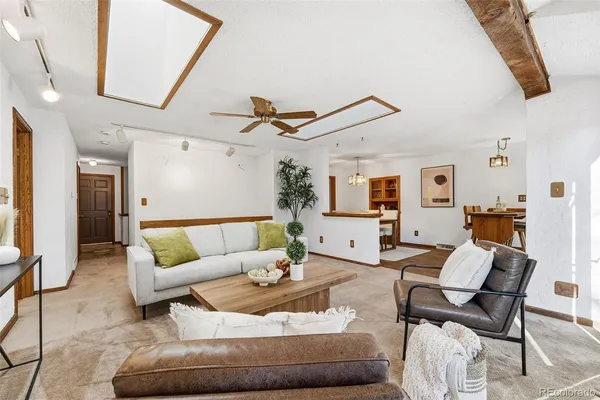 a living room with furniture and a ceiling fan