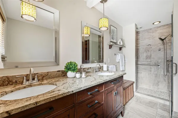 a bathroom with a granite countertop double vanity sink and a mirror