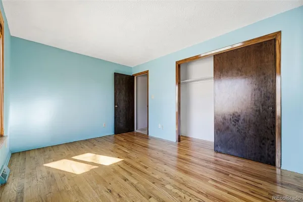 a view of empty room with wooden floor