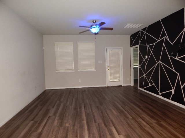 7103 Silverleaf Oak Street Conroe, TX 77304 - Photo 4 of 20 a view of an empty room with wooden floor and a ceiling fan