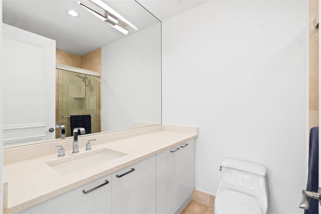 701 Southeast 21st Avenue, Unit 109 Deerfield Beach, FL 33441 - Photo 16 of 34 a bathroom with a sink a toilet and mirror